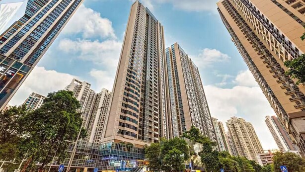 A high-rise building with multiple floors, surrounded by other tall buildings and trees. - Aifte International Apartment (Guangzhou)