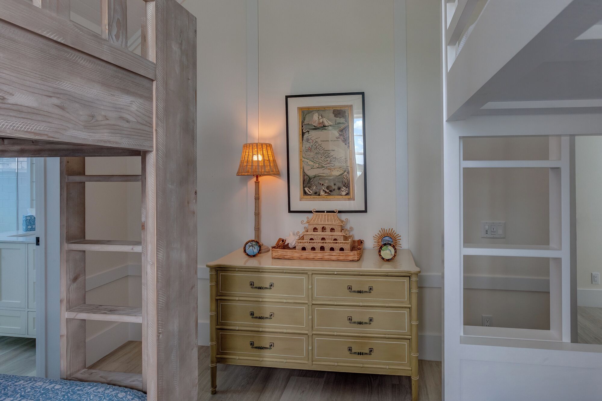 A room with a wooden cabinet, a framed map, a lamp, and a small decorative boat.