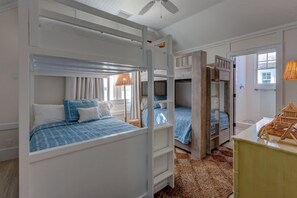 Une chambre avec des lits superposés, un bureau et un petit objet décoratif.