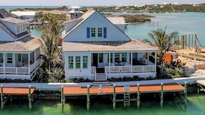 Una casa costera con un porche, un muelle y vista al mar.