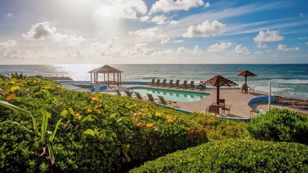 A pool area with lounge chairs and a gazebo overlooking the ocean. - Ocean View Cottage at Abaco Inn (Elbow cay)