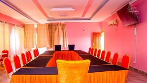A conference room with a long table, red chairs, and a yellow chair in the foreground. - Ten Villa Resort Lodwar (Lodwar)