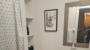 Een badkamer met toilet, wastafel en een fotokader aan de muur.