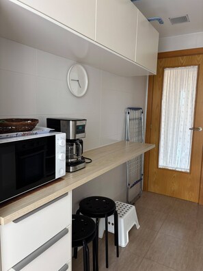 A compact kitchenette with a microwave, coffee maker, and a small refrigerator. - Lovely apartment with garage in Ares (Ares)