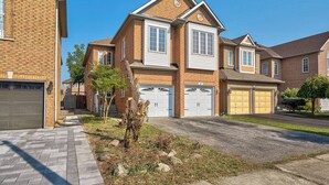 A two-story residential house with a brick facade, white trim, and a garage with two doors. - Family frieindly house in richmond hill 7beds (Richmond Hill)
