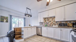 A modern kitchen with white cabinets, a tiled backsplash, and a built-in microwave. - Family frieindly house in richmond hill 7beds (Richmond Hill)