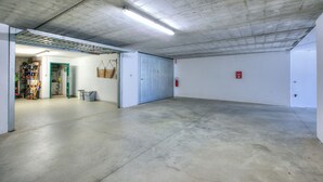 Ett rymligt inomhusområde med ett betonggolv och -tak, en dörr som leder till ett annat rum och en brandsläckare som är monterad på väggen.