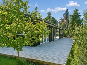A modern house with a wooden deck, large windows, and a view of the surrounding greenery. - "Amitola" - 800m from the sea by Interhome (Højby)