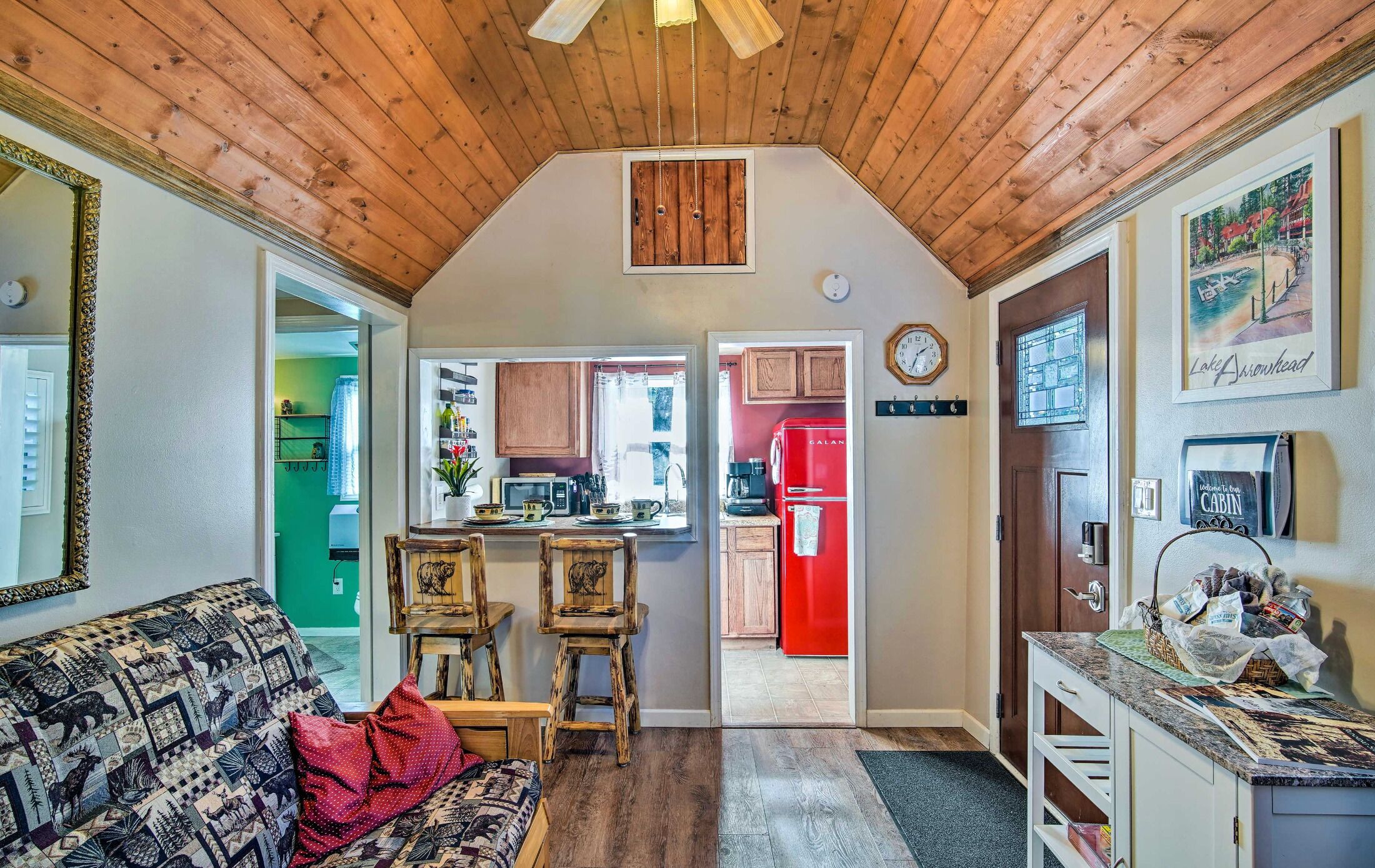 Living space featuring vaulted wood ceilings, a breakfast bar, and a view into the kitchen.