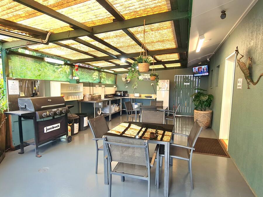 Una cocina con una parrilla Jumbuck, electrodomésticos de acero inoxidable y una mesa de comedor con sillas.