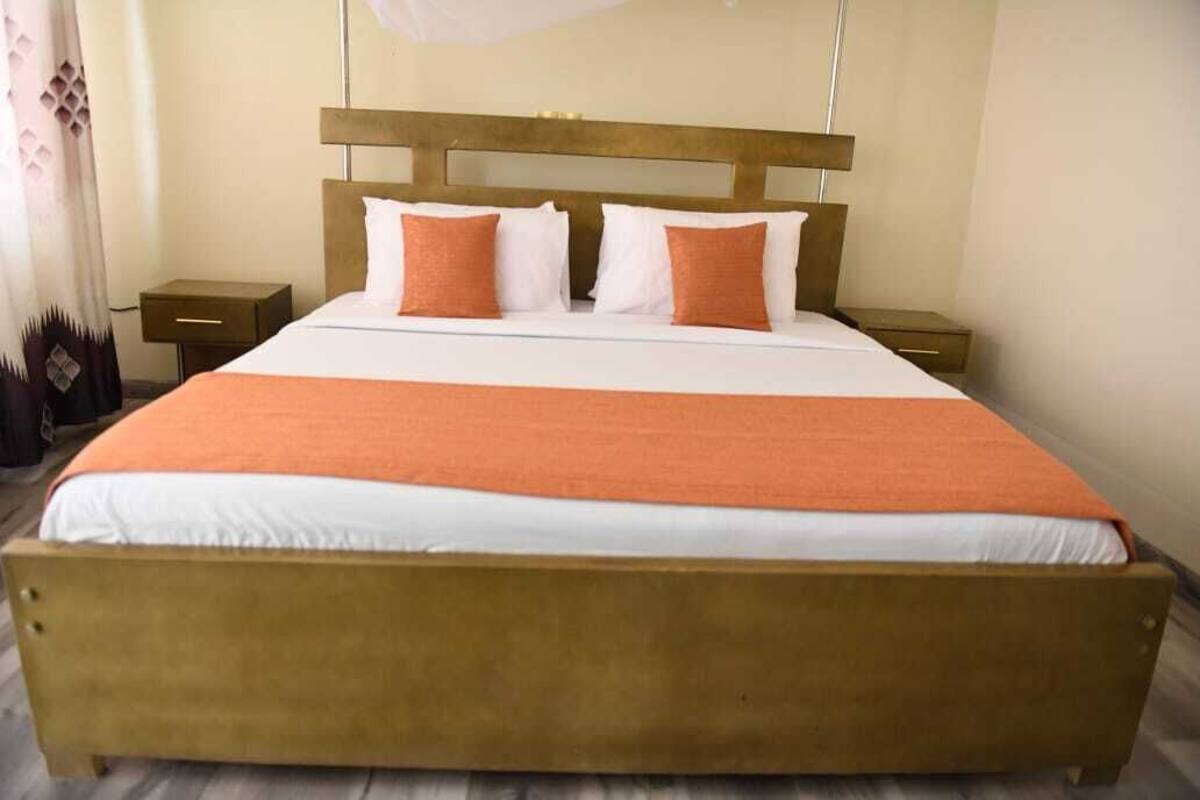A standard hotel room with a single bed, a nightstand, and a bedside table.