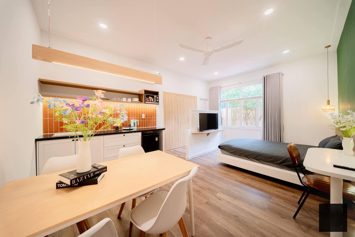 Una habitación de hotel moderna con comedor, kitchenette y una cama con vistas.