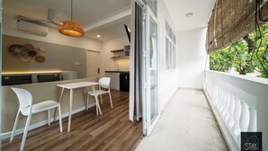 A modern kitchen with a dining area, a ceiling fan, and a view of greenery outside. - Stay Studio Villa Hideaway (Ho Chi Minh City)
