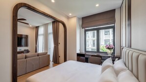 A modern hotel room with a large bed, a desk, a sofa, and a view of the city through a large window. - Luxury Apartment Manhattan Grand Park By An Gia Hospitality (Ho Chi Minh City)