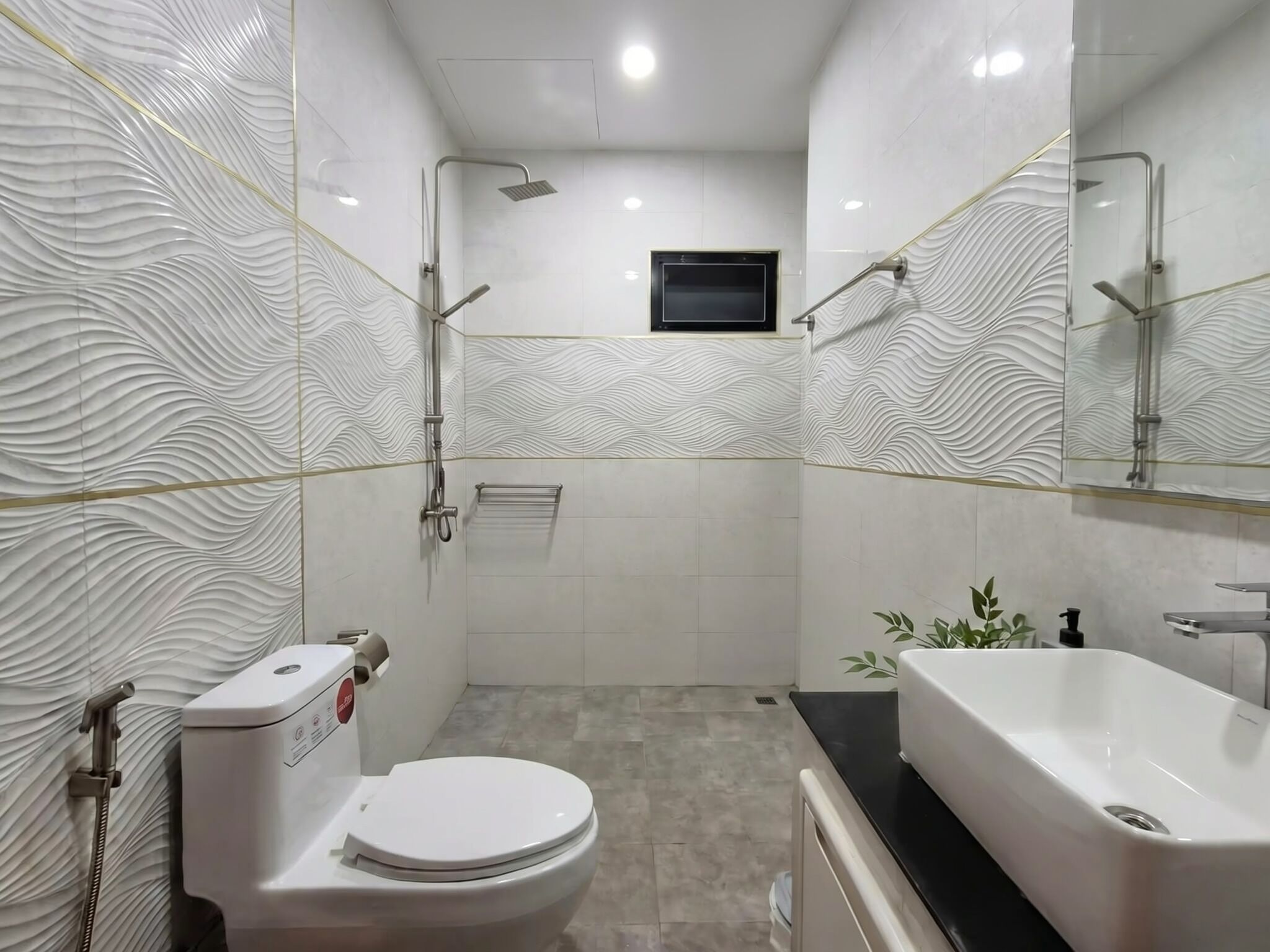 Een moderne badkamer met toilet, douche en wastafel.
