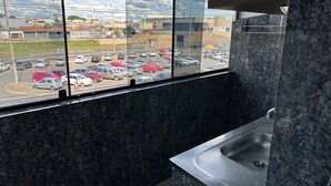 Una cocina con un amplio ventanal que da a un estacionamiento y edificios.
