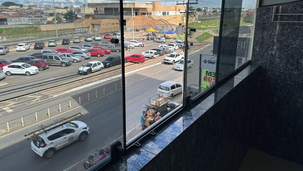 Vista desde una ventana sobre una calle concurrida, con coches y una vía de tren.