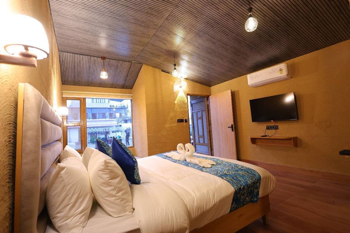 Une chambre d’hôtel équipée d’un lit, d’un téléviseur fixé au mur et d’un appareil de climatisation.