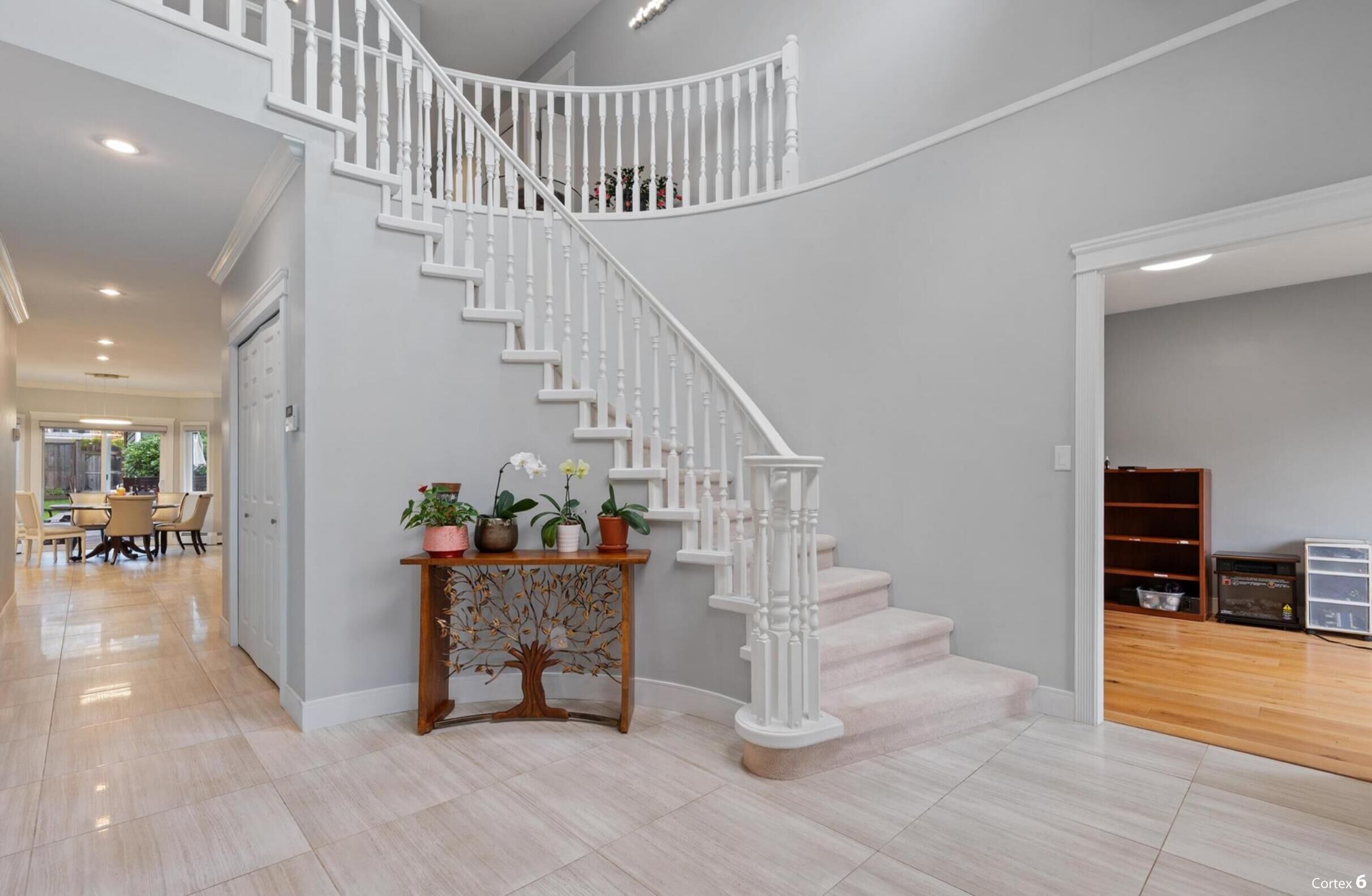 Eine moderne Treppe mit weißen Wangen und einem hölzernen Konsolentisch mit Blumentöpfen.