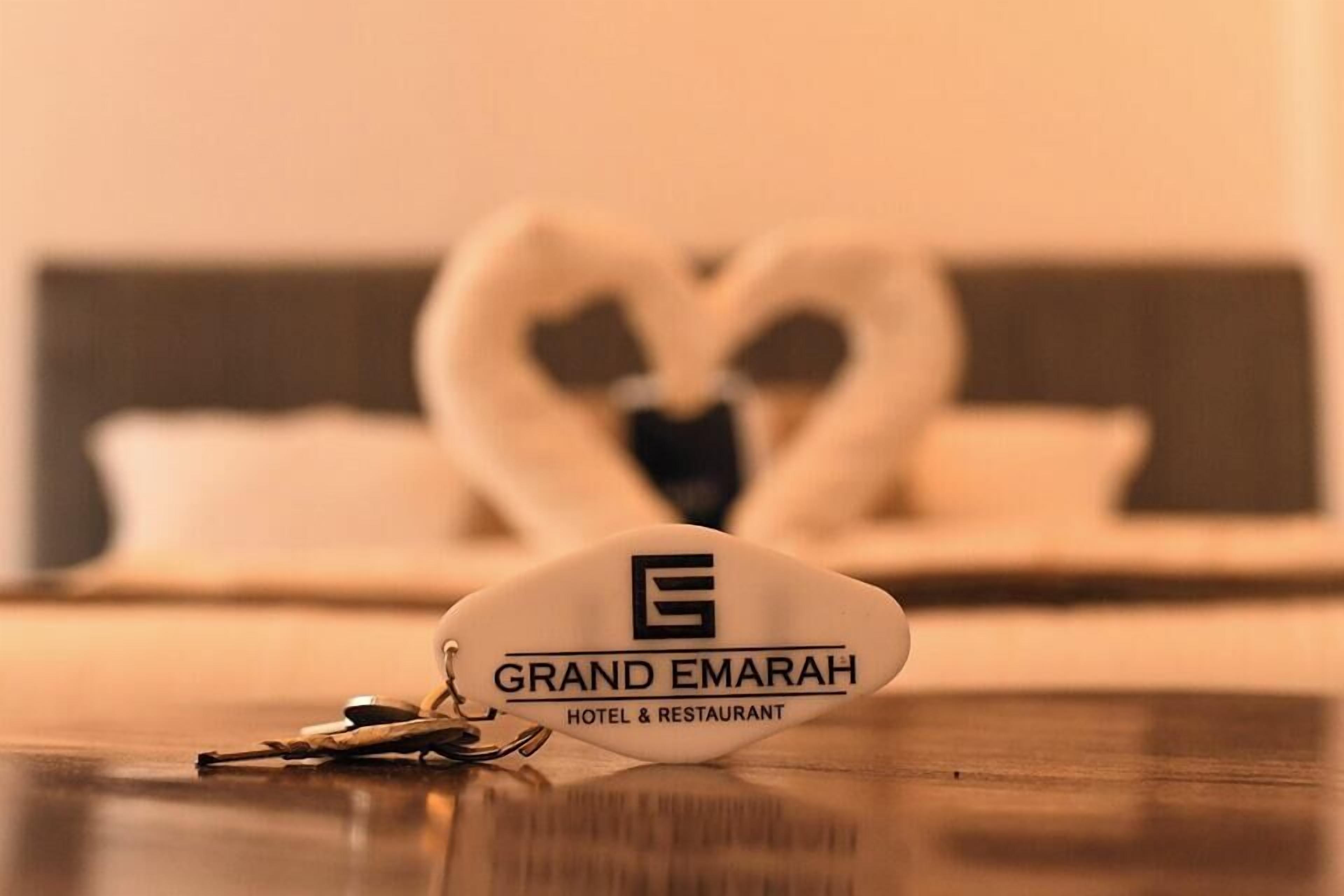 A hotel keychain with 'GRAND EMARAH HOTEL & RESTAURANT' text.