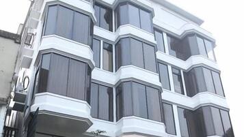 A modern building with a sign for "Grand Emarah" hotel and restaurant.