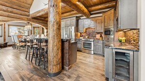 Una cocina amplia con vigas de madera, encimeras de granito y electrodomésticos de acero inoxidable.
