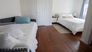 Una camera da letto con due letti, un armadio e un comodino.
