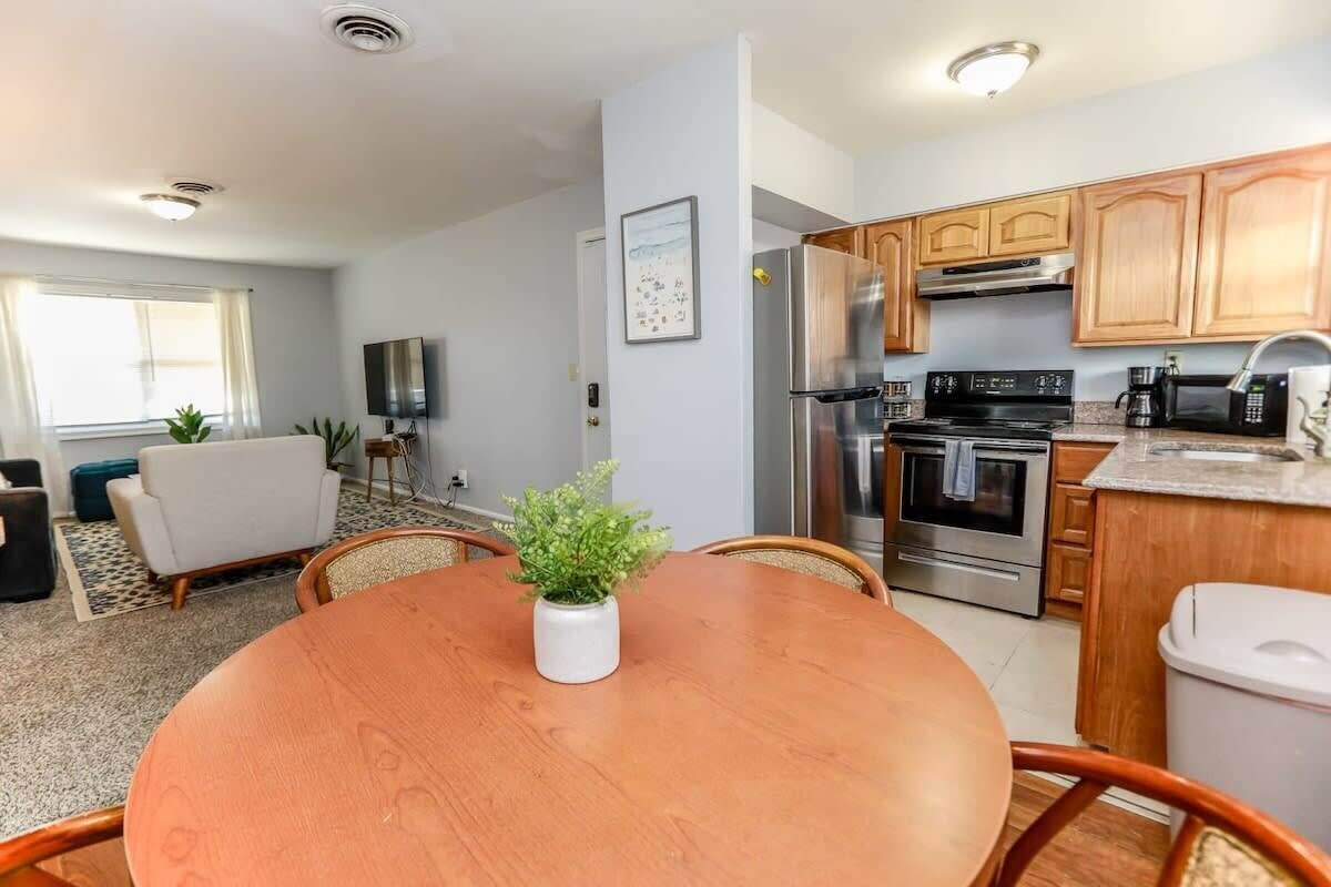 A modern kitchen with wooden cabinets, a stainless steel refrigerator, and a built-in oven.