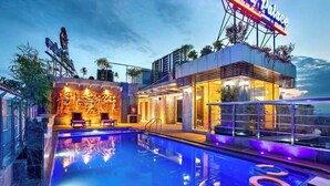 A modern hotel with a swimming pool, outdoor seating, and a neon sign. - Grand Palace Sylhet (Sylhet)