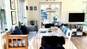 A spacious room with a long dining table, a wooden bench, a mounted animal head, and a television. - Perfect base near beach and shops (Væggerløse)