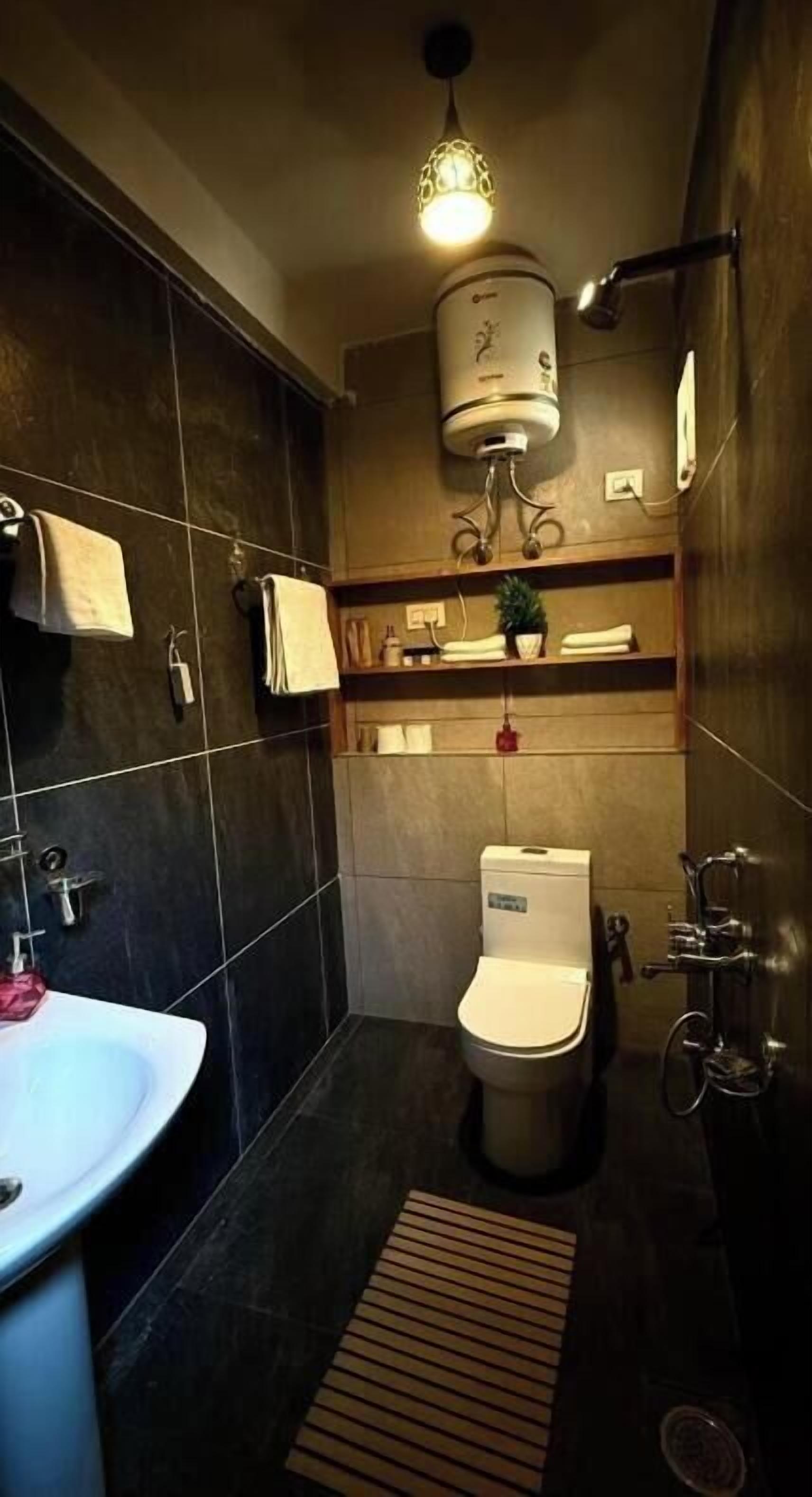 Un baño pequeño con lavamanos blanco, inodoro y ducha.