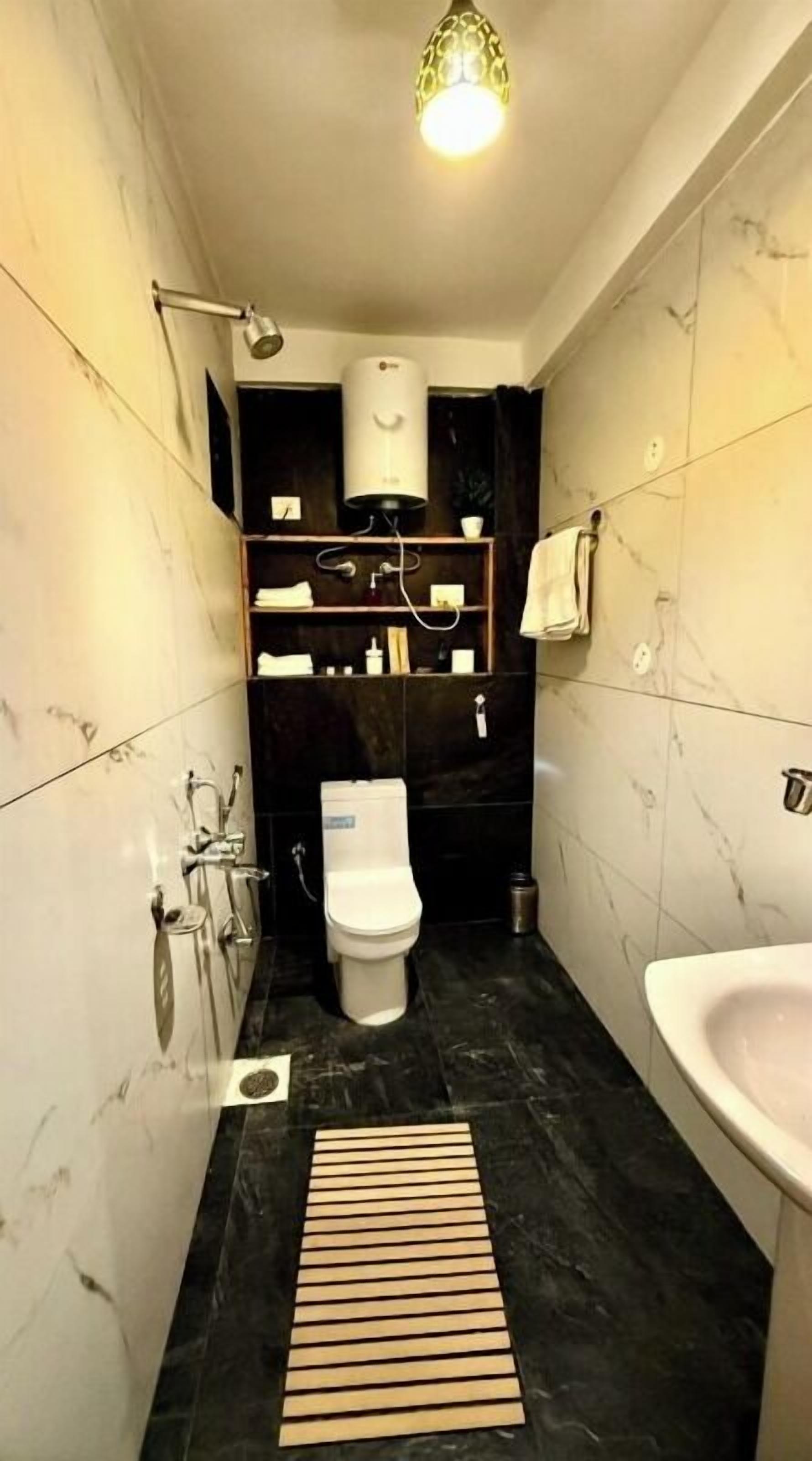 A compact bathroom with a toilet, sink, and shower.