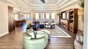 A spacious living room with a large sectional sofa, a TV, and a fireplace. - Upscale 4 bedroom family home near Zion w pool & hot tub (Kanab)
