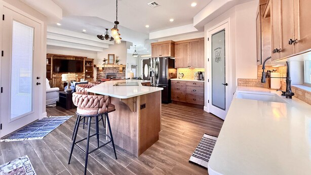 A spacious kitchen with a large island, wooden cabinets, and modern appliances. - Upscale 4 bedroom family home near Zion w pool & hot tub (Kanab)