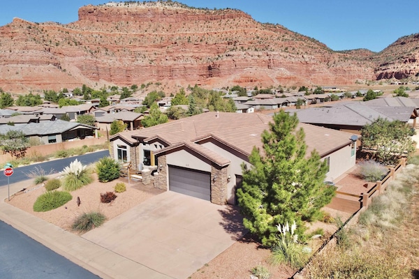 Luxury home on a corner lot in a beautiful neighborhood wrapped in stunning red rock cliffs.