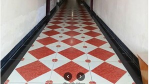 A long, narrow hallway with a red and white checkered floor, leading to a door at the end. - World Beach Resort Cox's Bazar (Cox's Bazar)