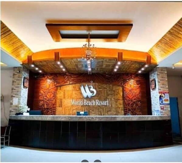 A reception area with a wooden wall, a chandelier, and a sign reading "World Beach Resort". - World Beach Resort Cox's Bazar (Cox's Bazar)