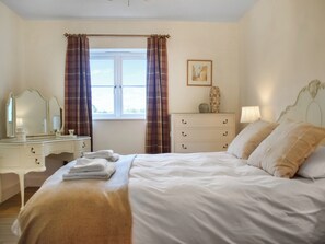 A hotel room with a bed, a dresser, a mirror, and a window with curtains. - Holly Tree Barn - UK49607 (Minshull Vernon, near Nantwich)