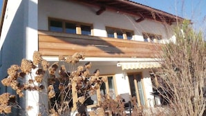 Un immeuble à deux étages, doté d’un toit plat, de grandes fenêtres et d’un balcon.