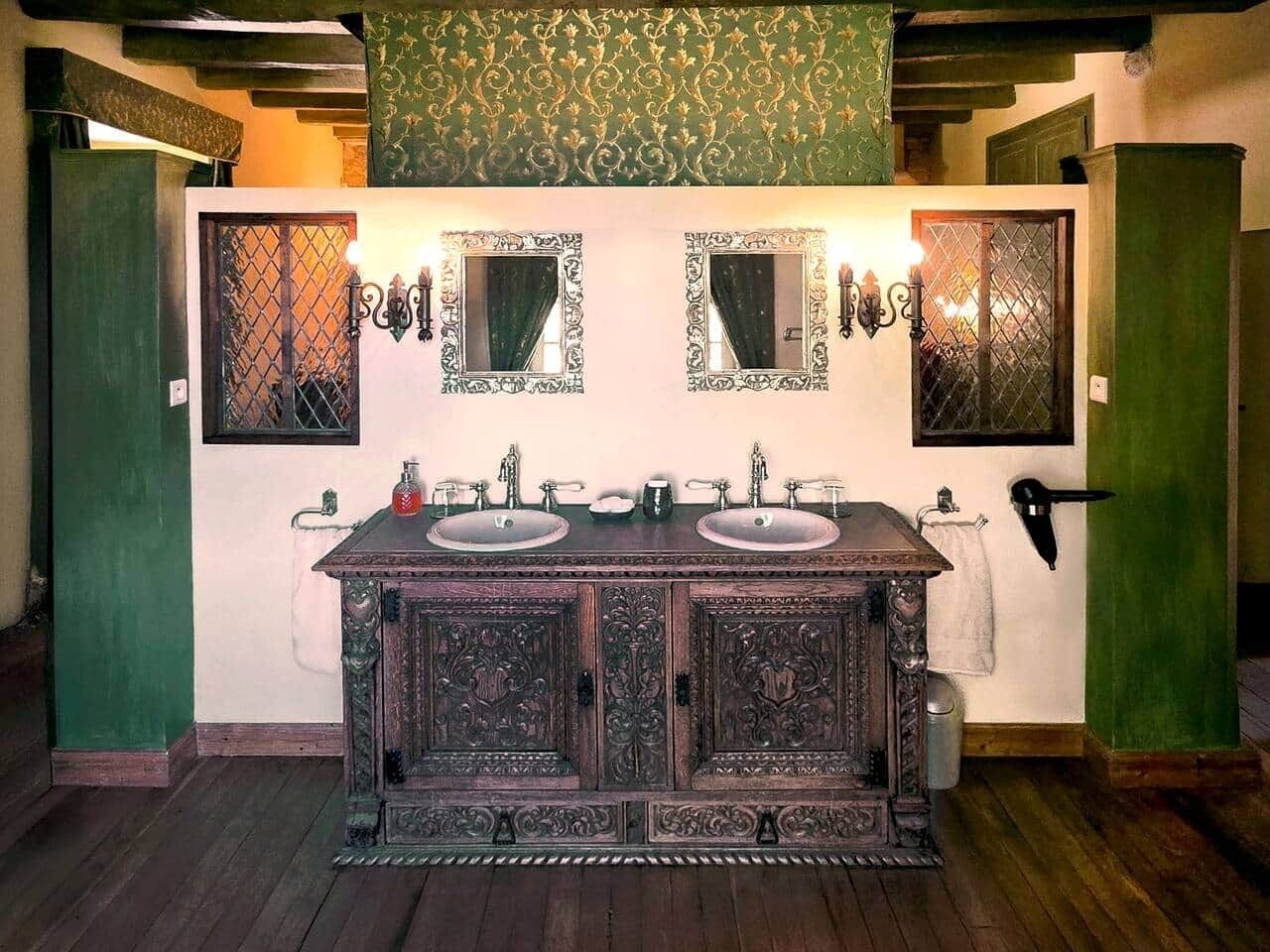 Une salle de bain avec un meuble-lavabo en bois, deux vasques et des appliques murales décoratives.