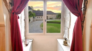 Una habitación estrecha con ventana que da a un patio.