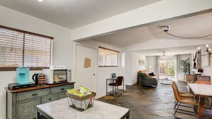 A spacious living area with a kitchen, dining table, and seating. - Retro Vegas Getaway - Just 2 Miles to The Vegas Strip with a Pool & Hot Tub (Las Vegas)