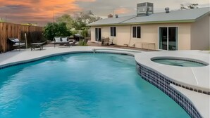 A swimming pool with a hot tub, a wooden fence, and a house with a flat roof. - Retro Vegas Getaway - Just 2 Miles to The Vegas Strip with a Pool & Hot Tub (Las Vegas)