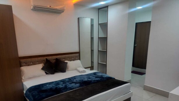 Ein modernes Schlafzimmer mit einem großen Bett, Einbauschränken und einem Spiegel.