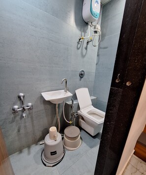 A bathroom with a toilet, sink, and shower.
