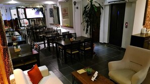 A modern living room with a sofa, armchair, coffee table, and dining area with chairs and a table. - Paperon Butik Otel (Erdemli)