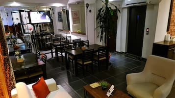 Ett modernt vardagsrum med en soffa, fåtölj, soffbord och en matplats med stolar och ett bord.