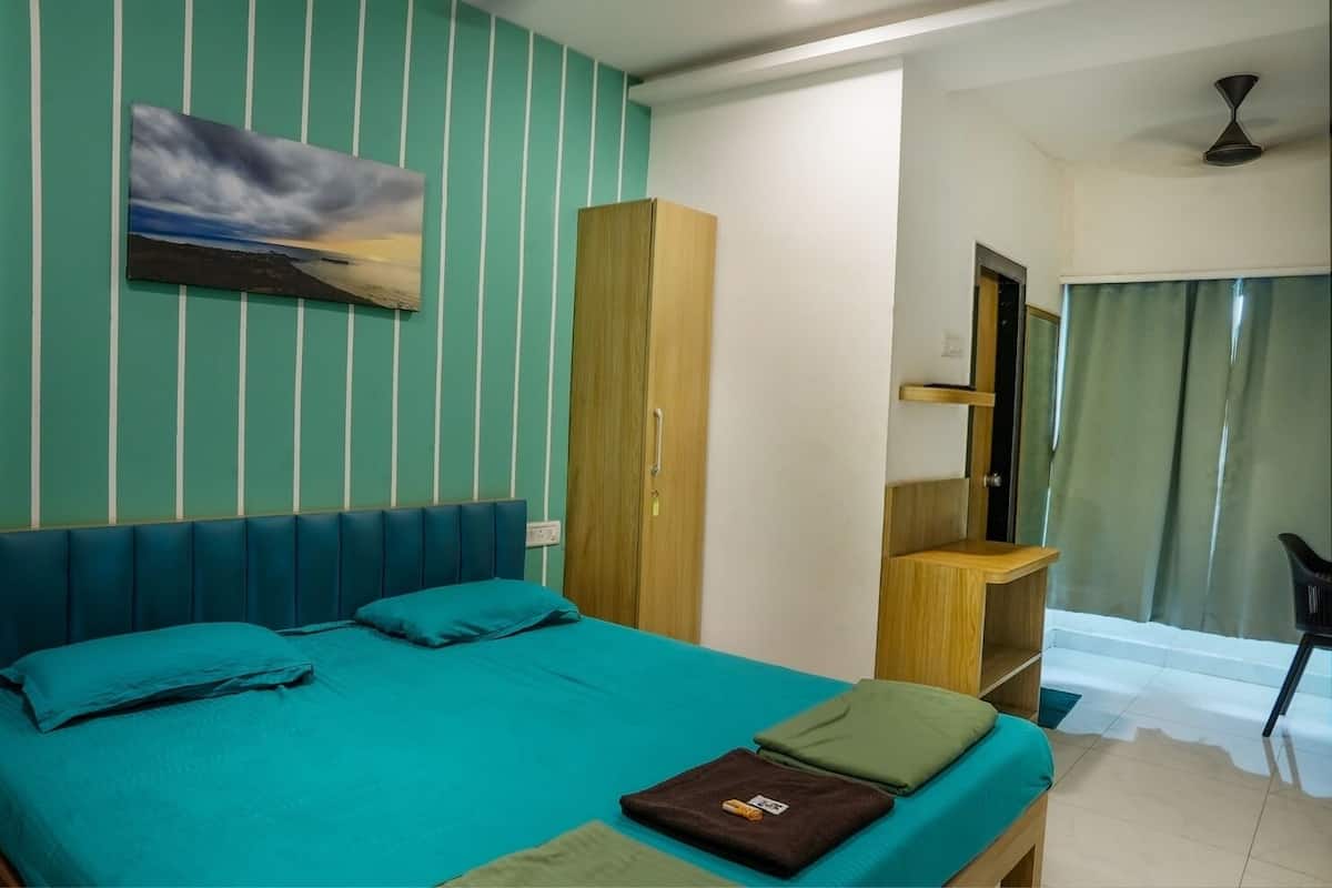 A room with a bed, a wardrobe, a desk, and a window with curtains.
