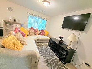 A living room with a sofa, a TV, a lamp, and a patterned rug. - Spacious Private 2BR Suite in Abingdon (Abingdon)