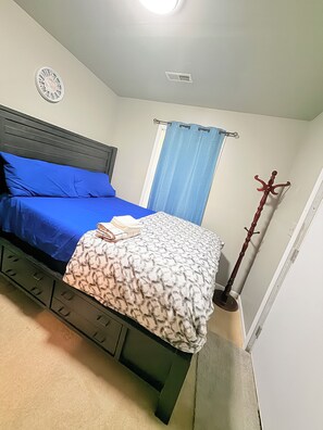 A bedroom with a bed, a clock on the wall, a window with curtains, and a coat rack. - Spacious Private 2BR Suite in Abingdon (Abingdon)